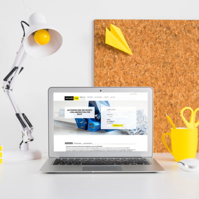 artaker.com Website sichtbar in Laptop auf Schreibtisch mit Lampe und Pinwand im Hintergrund