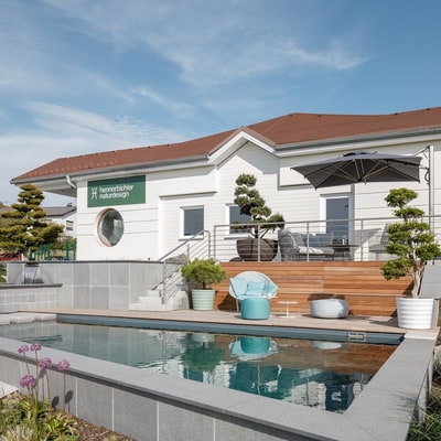 Haus mit Terrasse und Pool davor von hennerbichler naturdesign gestaltet