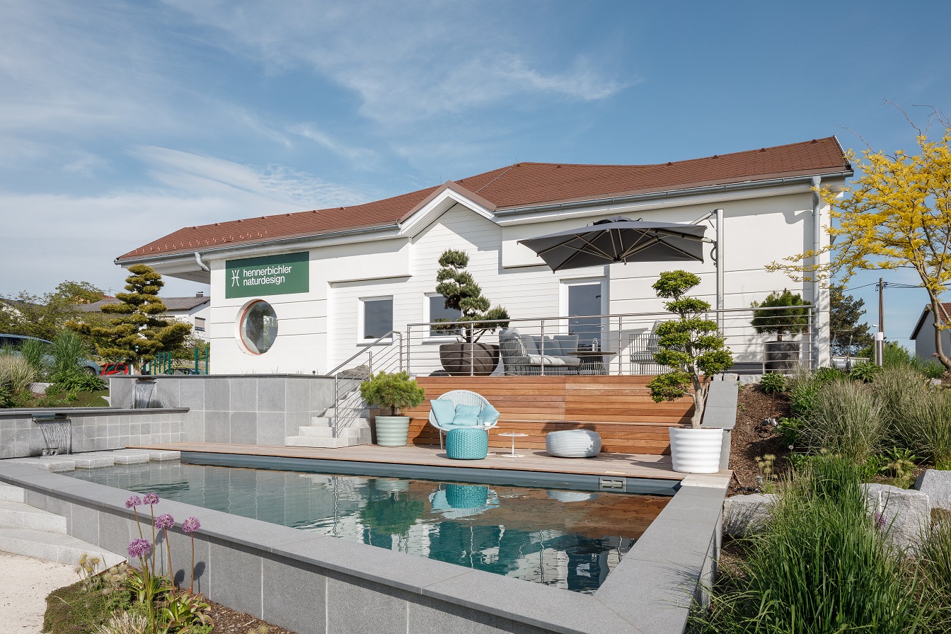 Haus mit Terrasse und Pool davor von hennerbichler naturdesign gestaltet