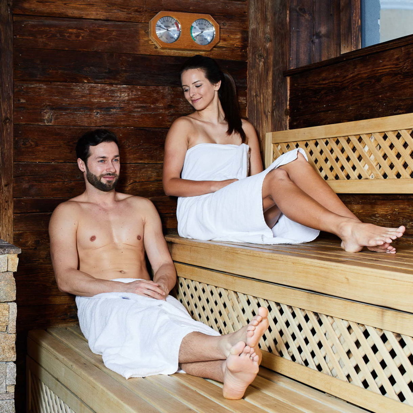 Mann und Frau sitzend in einer Sauna