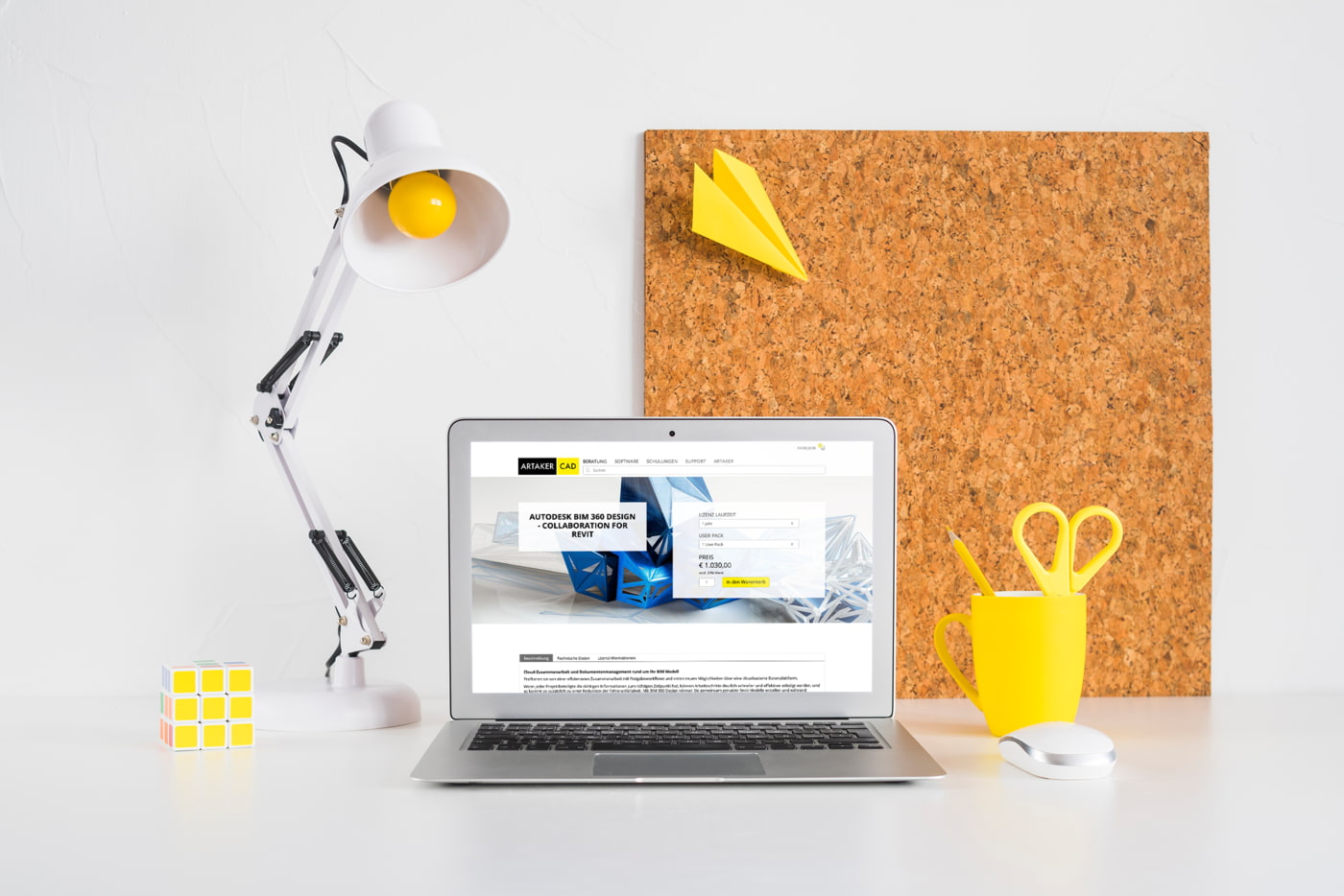 artaker.com Website sichtbar in Laptop auf Schreibtisch mit Lampe und Pinwand im Hintergrund