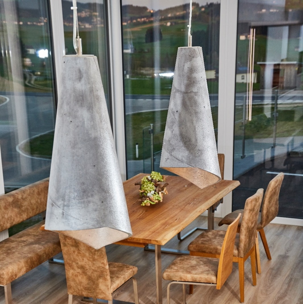 Lampen aus Beton über Tisch mit Stühlen