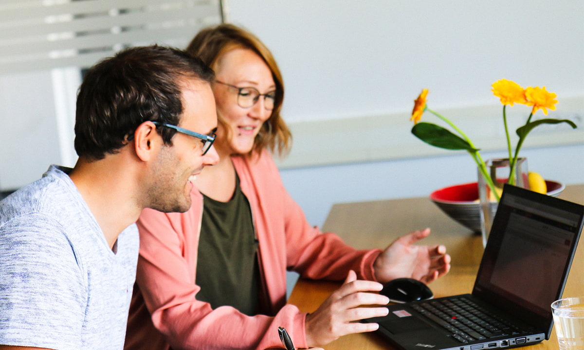 Peter & Silke - Mitarbeiter der Webagentur XORTEX beim Laptop sitzend im Kommunikationsraum