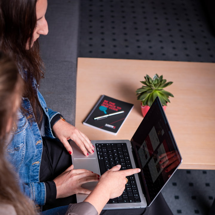 XORTEX eBusiness GmbH Zwei Personen mit Laptop und Notizheft