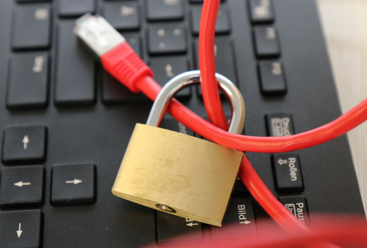 DSGVO mit XORTEX rotes Netzwerkkabel mit Vorhängeschloss vor Tastatur